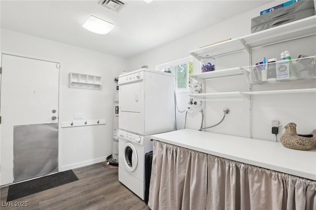 3155 Duneville St, Las Vegas, NV 89146 - clothes washing area with stacked washer / drying machine, laundry area, visible vents, baseboards, and dark wood-type flooring