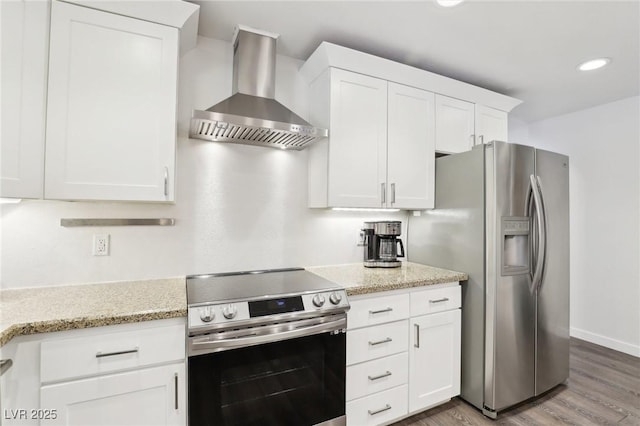 3155 Duneville St, Las Vegas, NV 89146 - kitchen with wood finished floors, white cabinets, light stone countertops, wall chimney range hood, and appliances with stainless steel finishes