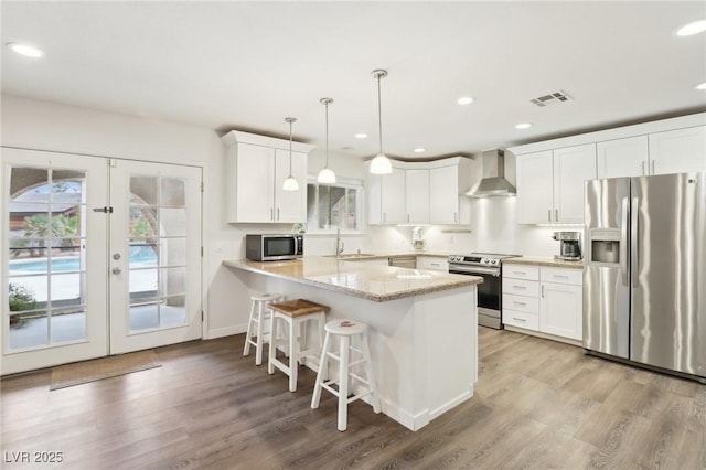 3155 Duneville St, Las Vegas, NV 89146 - kitchen with french doors, a sink, a peninsula, wall chimney range hood, and appliances with stainless steel finishes