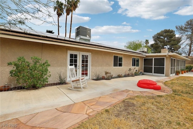 3155 Duneville St, Las Vegas, NV 89146 - back of property with roof mounted solar panels, a sunroom, stucco siding, and french doors