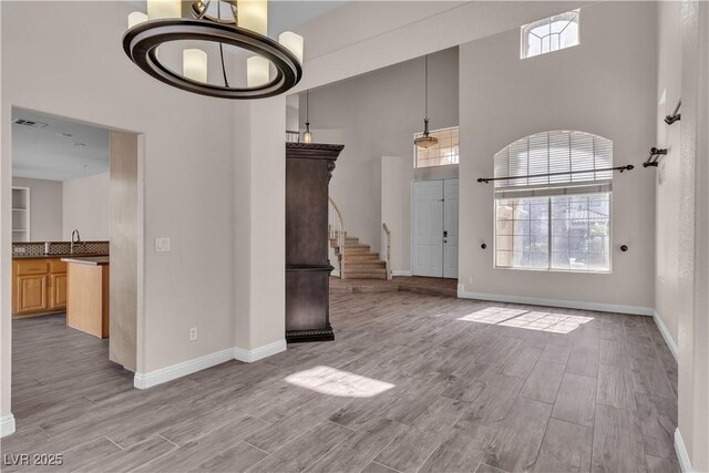 1717 Double Arch Ct, Las Vegas, NV 89128 - unfurnished living room with a high ceiling, baseboards, wood finished floors, and stairs