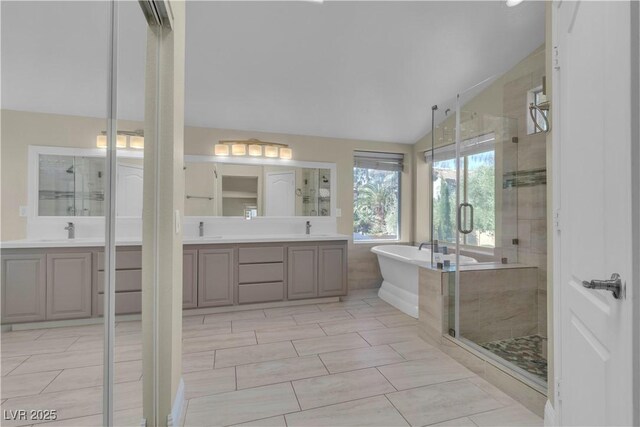 1717 Double Arch Ct, Las Vegas, NV 89128 - bathroom with vaulted ceiling, a stall shower, two vanities, and a sink
