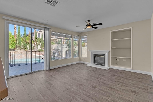 unfurnished living room featuring healthy amount of natural light, a ceiling fan, and wood finished floors