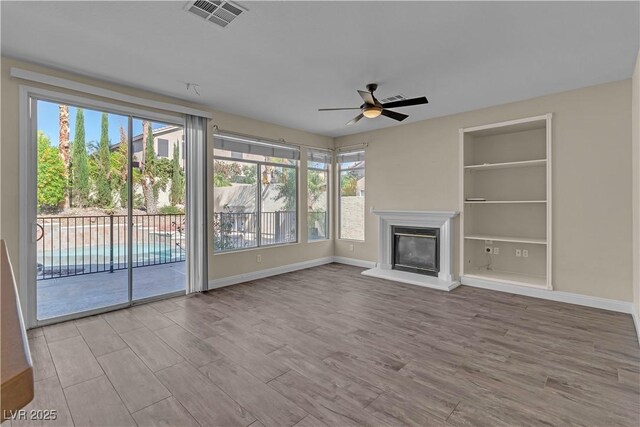 1717 Double Arch Ct, Las Vegas, NV 89128 - unfurnished living room featuring healthy amount of natural light, a ceiling fan, and wood finished floors