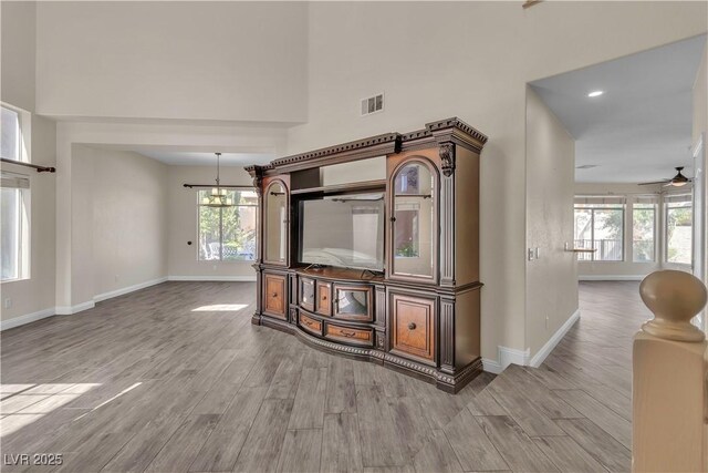 1717 Double Arch Ct, Las Vegas, NV 89128 - interior space with wood finished floors, a notable chandelier, visible vents, baseboards, and a towering ceiling