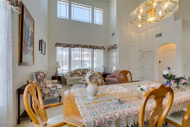 dining room featuring a high ceiling, arched walkways, and a chandelier