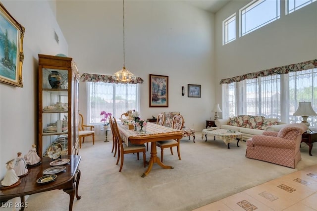 dining area featuring a high ceiling and carpet flooring