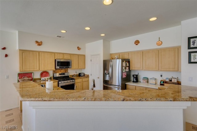 kitchen featuring appliances with stainless steel finishes, light brown cabinets, a peninsula, recessed lighting, and light stone countertops