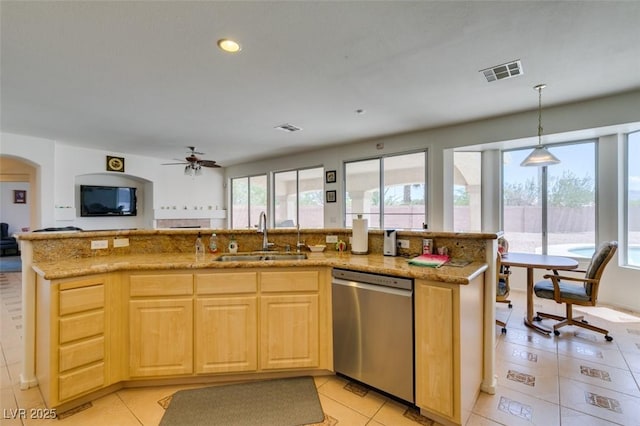 kitchen featuring dishwasher, a sink, light brown cabinetry, open floor plan, and light tile patterned floors