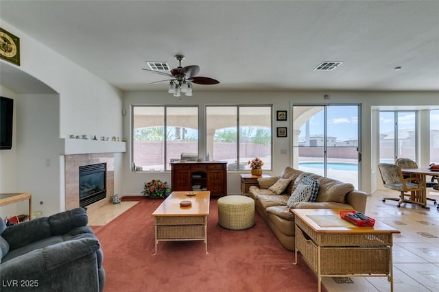 living area with a fireplace and ceiling fan