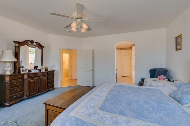 bedroom with arched walkways, carpet floors, and a ceiling fan