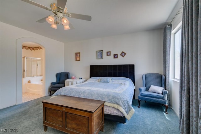 carpeted bedroom with arched walkways, ensuite bathroom, and a ceiling fan