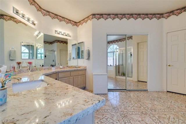 bathroom featuring a stall shower, two vanities, and marble finish floors