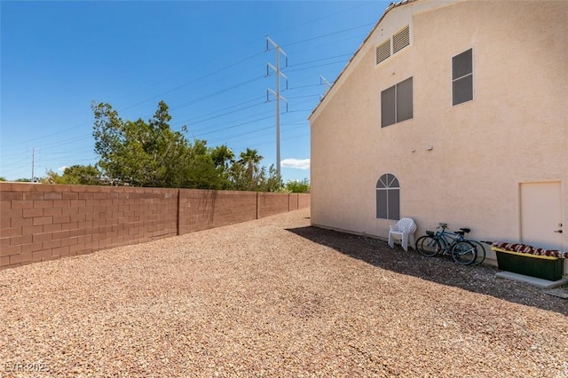 view of side of property featuring a fenced backyard and stucco siding