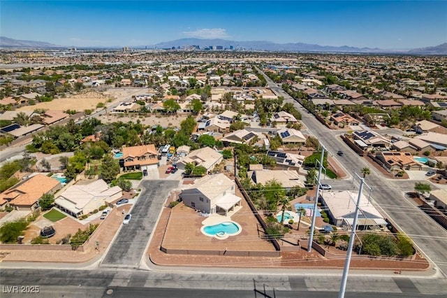 aerial perspective of suburban area with a mountainous background and a pool