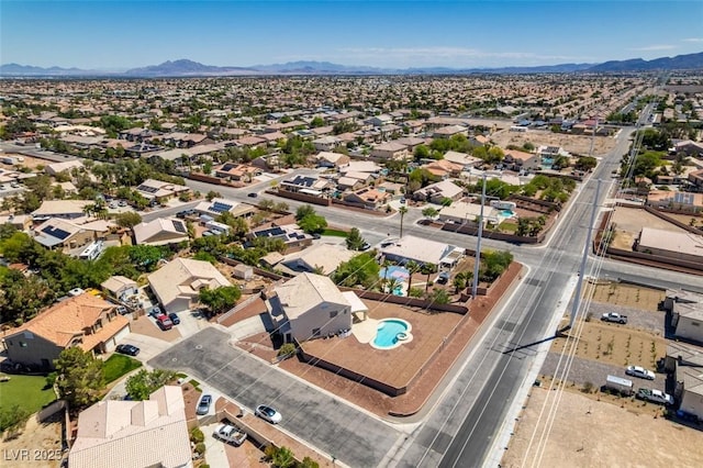 aerial perspective of suburban area featuring a mountainous background and a pool area
