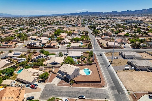 aerial view of residential area with a mountainous background and a pool area