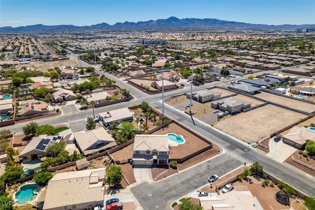aerial perspective of suburban area with a pool and mountains
