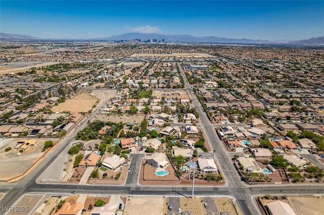 aerial view of property's location featuring a mountainous background and nearby suburban area