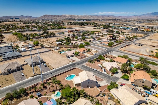 aerial perspective of suburban area with a mountainous background and a pool