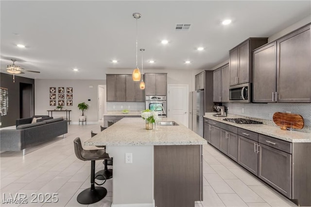 5741 N Park St, Las Vegas, NV 89149 - kitchen with a breakfast bar, open floor plan, visible vents, appliances with stainless steel finishes, and tasteful backsplash