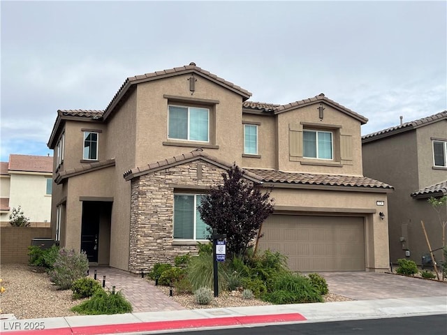 528 Sunny Pointe St, Henderson, NV 89011 - view of front of property featuring a tile roof, stone siding, a garage, stucco siding, and driveway