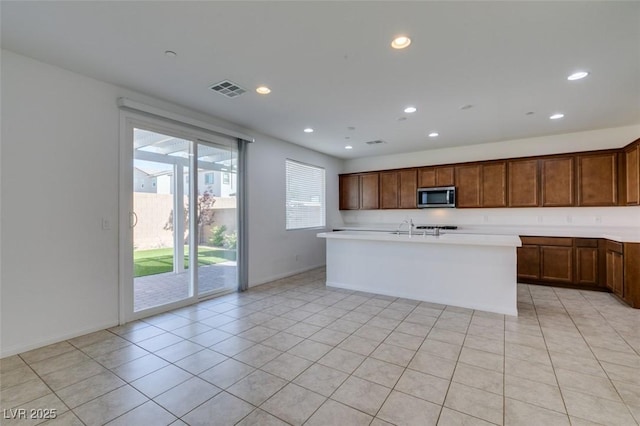 528 Sunny Pointe St, Henderson, NV 89011 - kitchen featuring stainless steel microwave, light countertops, recessed lighting, an island with sink, and a sink