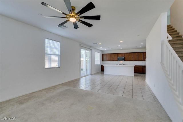 528 Sunny Pointe St, Henderson, NV 89011 - unfurnished living room featuring light colored carpet, light tile patterned floors, stairway, recessed lighting, and ceiling fan