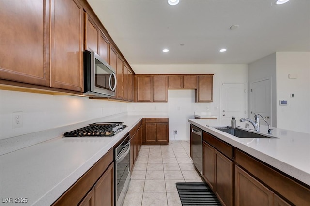 528 Sunny Pointe St, Henderson, NV 89011 - kitchen with stainless steel appliances, a sink, brown cabinetry, recessed lighting, and light countertops