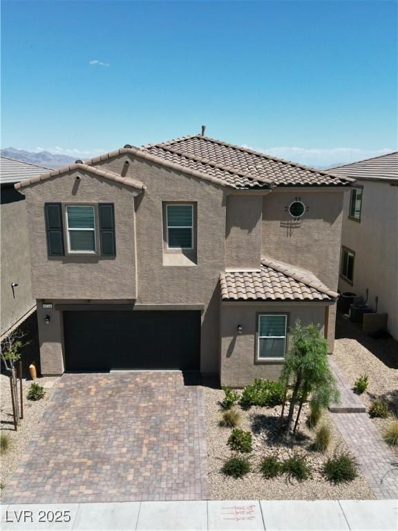 8724 Scalpay St, Las Vegas, NV 89166 - view of front facade with a tiled roof, stucco siding, a garage, and driveway