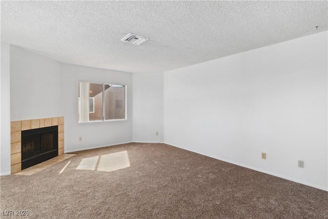 2191 Bay Club Dr Unit 204, Laughlin, NV 89029 - unfurnished living room with a textured ceiling, a tiled fireplace, visible vents, and carpet
