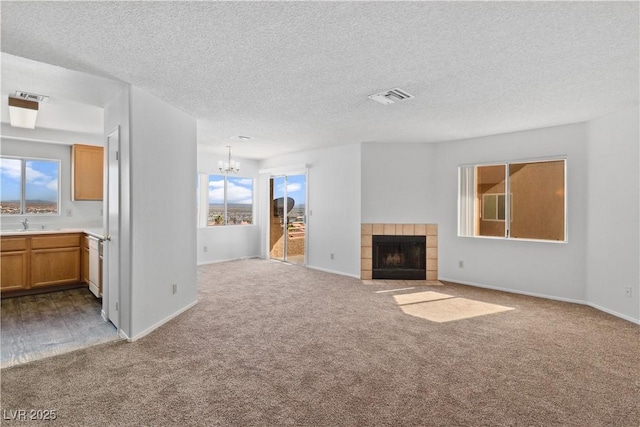 2191 Bay Club Dr Unit 204, Laughlin, NV 89029 - unfurnished living room with a tile fireplace, carpet, visible vents, and a notable chandelier