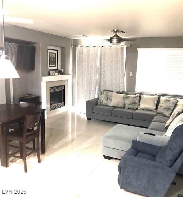 6030 Halehaven Dr, Las Vegas, NV 89110 - living area featuring a fireplace, ceiling fan, and light tile patterned floors