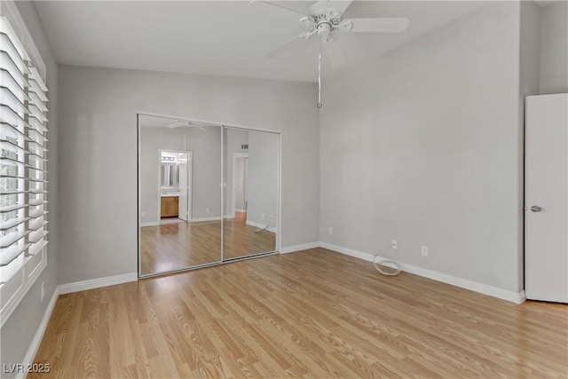 unfurnished bedroom featuring baseboards, a closet, light wood finished floors, and ceiling fan