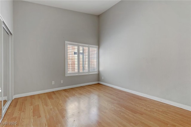 spare room featuring light wood finished floors and baseboards