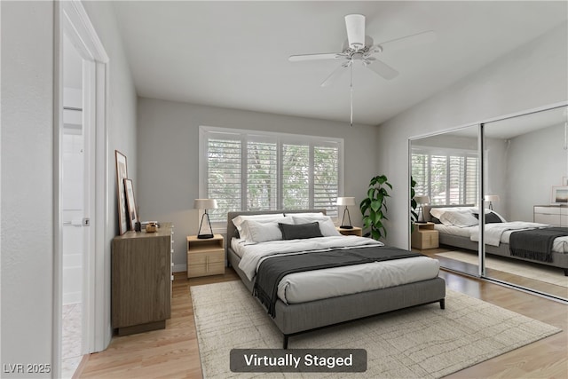 bedroom with a ceiling fan, a closet, light wood-style flooring, and vaulted ceiling