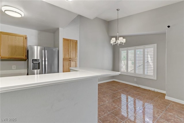 kitchen with a notable chandelier, baseboards, hanging light fixtures, tile patterned floors, and stainless steel refrigerator with ice dispenser