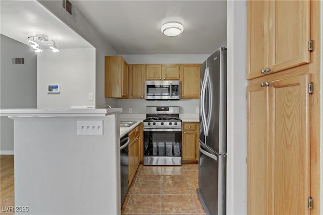 kitchen with light brown cabinets, stainless steel appliances, visible vents, a peninsula, and light countertops