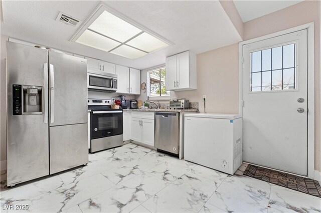 5939 Vegas Dr, Las Vegas, NV 89108 - kitchen with white cabinets, stainless steel appliances, marble finish floor, and visible vents