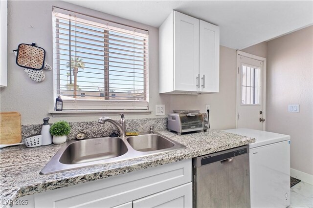 5939 Vegas Dr, Las Vegas, NV 89108 - kitchen featuring a healthy amount of sunlight, a sink, stainless steel dishwasher, and white cabinets
