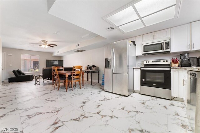 5939 Vegas Dr, Las Vegas, NV 89108 - kitchen with light countertops, open floor plan, a ceiling fan, white cabinets, and appliances with stainless steel finishes
