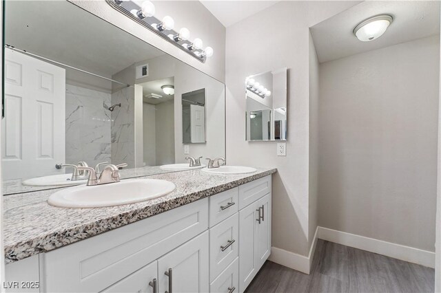 5939 Vegas Dr, Las Vegas, NV 89108 - bathroom with walk in shower, visible vents, wood finished floors, and a sink
