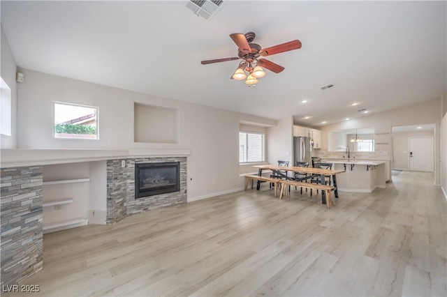 8136 Shady Glen Ave, Las Vegas, NV 89131 - living area with a fireplace, lofted ceiling, a ceiling fan, light wood-style floors, and recessed lighting