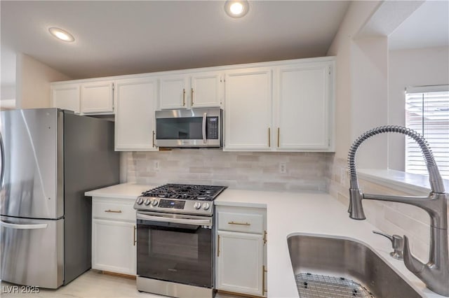 8136 Shady Glen Ave, Las Vegas, NV 89131 - kitchen with appliances with stainless steel finishes, light countertops, white cabinetry, tasteful backsplash, and recessed lighting