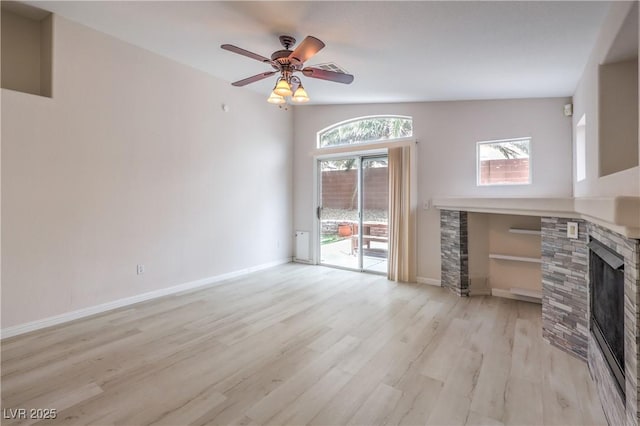 8136 Shady Glen Ave, Las Vegas, NV 89131 - unfurnished living room featuring a stone fireplace, light wood-type flooring, and ceiling fan