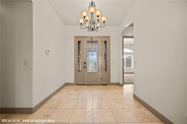 653 Paloma Cir, Mesquite, NV 89027 - entrance foyer with lofted ceiling, a notable chandelier, baseboards, light tile patterned floors, and arched walkways