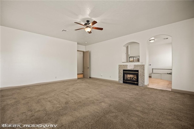 653 Paloma Cir, Mesquite, NV 89027 - unfurnished living room featuring baseboards, visible vents, ceiling fan, a high end fireplace, and light colored carpet