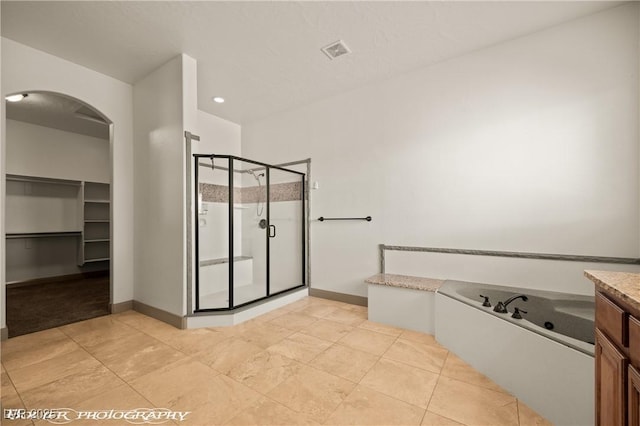 653 Paloma Cir, Mesquite, NV 89027 - bathroom featuring a stall shower, baseboards, a spacious closet, and a bath