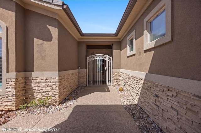 653 Paloma Cir, Mesquite, NV 89027 - property entrance featuring stone siding, stucco siding, and a gate