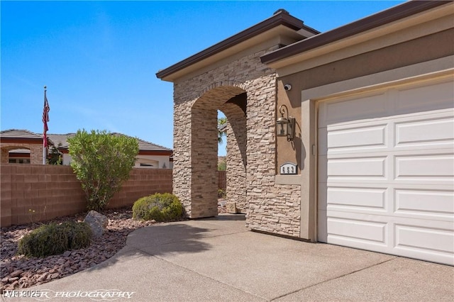 653 Paloma Cir, Mesquite, NV 89027 - view of home's exterior featuring fence, an attached garage, stucco siding, and stone siding